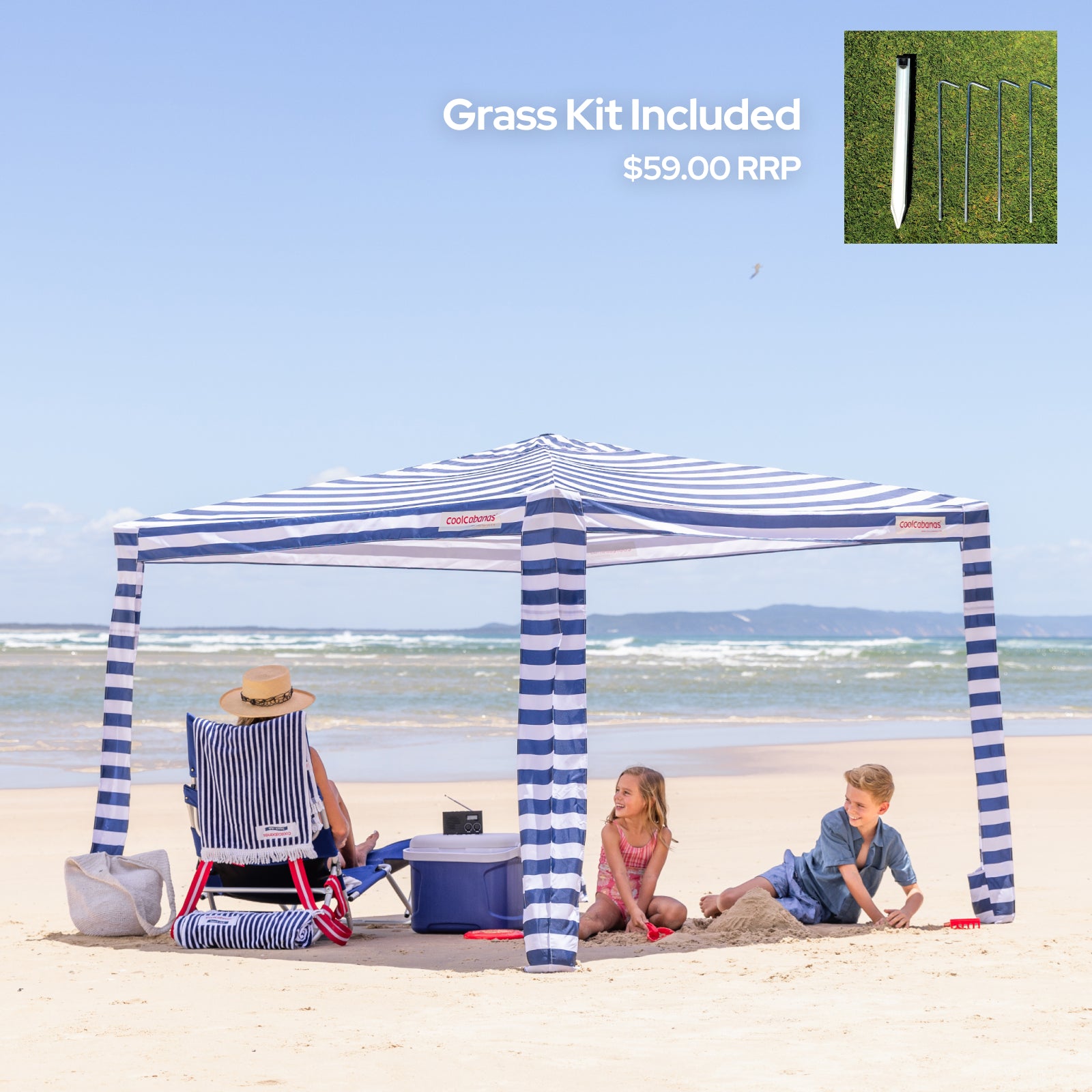 Large CoolCabana with striped design on a sandy beach with children playing.