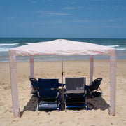 #color_byron-tangerine CoolCabanas beach sunshade tent set up on a sandy beach, providing shade and protection from the sun, perfect for family beach days, outdoor picnics, and seaside relaxation.