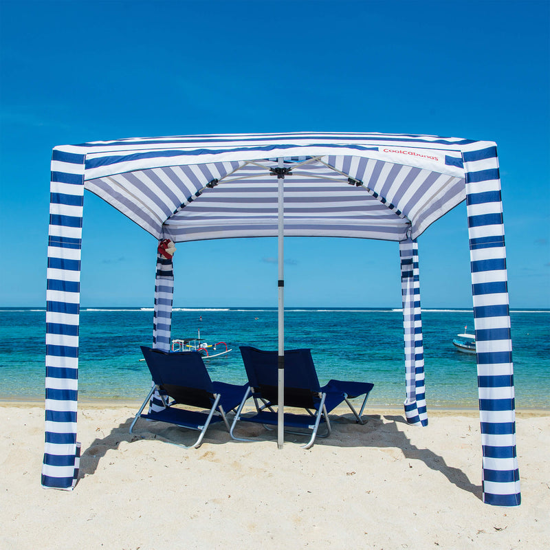 #color_navy stripes CoolCabanas beach sunshade tent set up on a sandy beach, providing shade and protection from the sun, perfect for family beach days, outdoor picnics, and seaside relaxation.